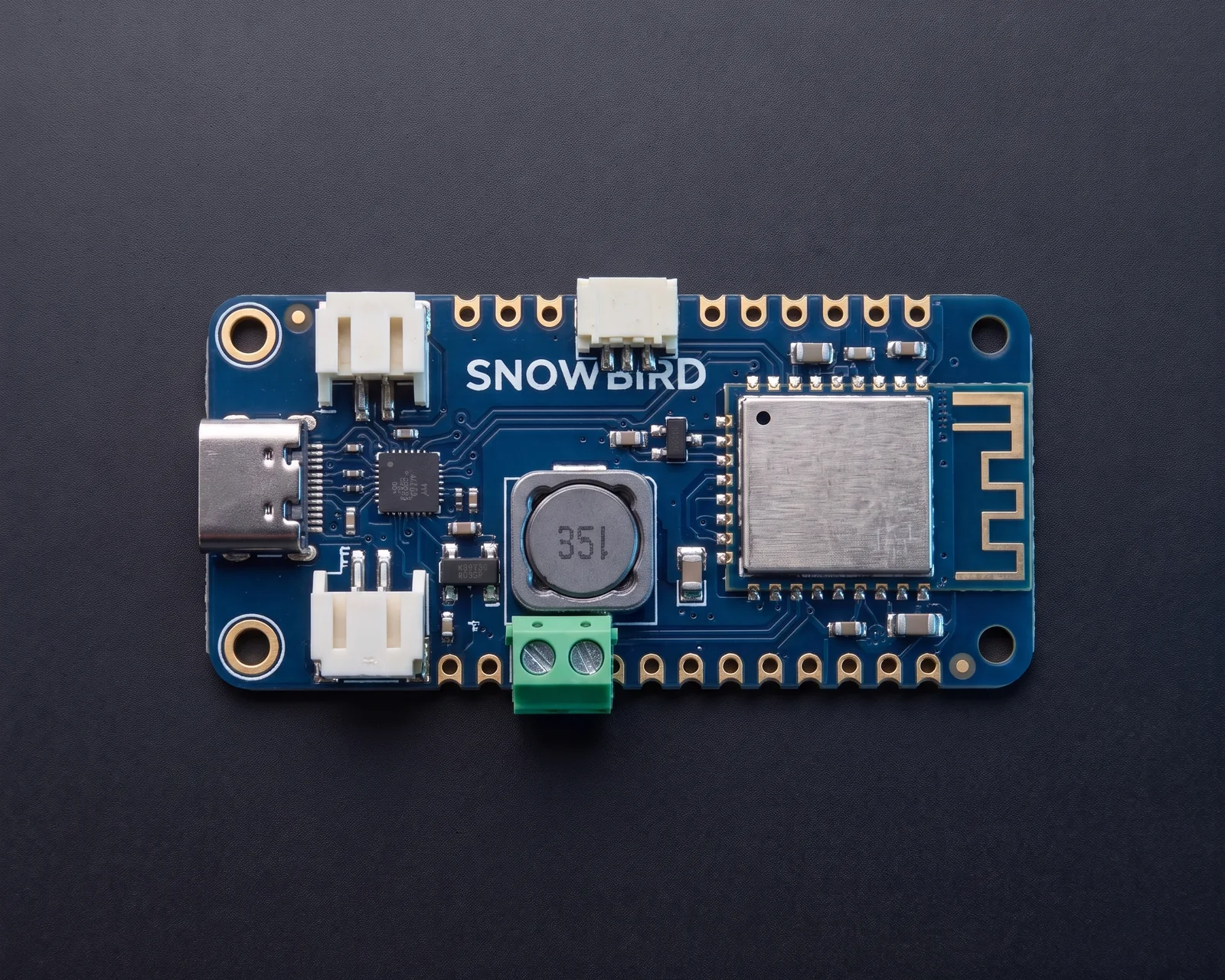 The Snowbird Feather 1S from directly above, showing the USB-C port, Qwiic and solar connectors at one end, the Bluetooth module at the other, and the battery connector, terminal block, charger and LEDs between them.